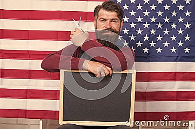 Providing training course. Hipster holding scissors and blackboard in training school. Bearded man giving training Stock Photo
