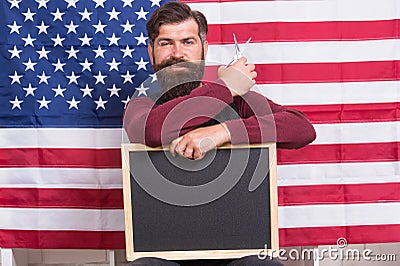 Providing training course. Hipster holding scissors and blackboard in training school. Bearded man giving training Stock Photo