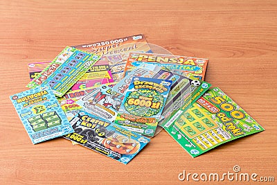 Scratch tickets on wooden table, low cost gambling Editorial Stock Photo