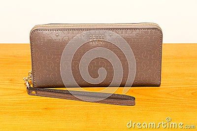 Guess est 1981 wallet on wooden table. Guess is an American clothing brand and retailer Editorial Stock Photo