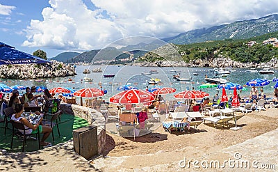 PRZNO, BUDVA RIVIERA AREA, MONTENEGRO, AUGUST 2, 2014: Panoramic view of the bay and city beach with many people in small lagoon i Editorial Stock Photo