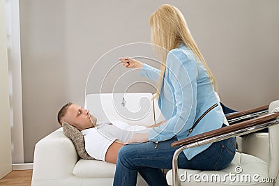 Psychiatrist Hypnotizing Patient Stock Photo