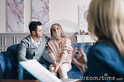 Beautiful and happy young couple visiting psychologist for relationship counseling. Stock Photo