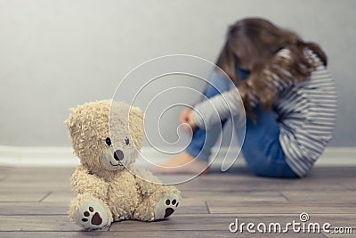 Psychological health concept. A teddy bear and in the background a teenage girl out of focus. Psychological assistance to children Stock Photo