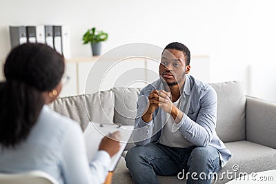 Psychological help service. Depressed male patient having psychotherapy session with counselor at mental health clinic Stock Photo