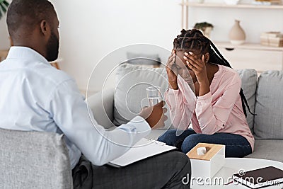 Psychologist Comforting Depressed Black Woman During Mental Therapy Session At Office Stock Photo
