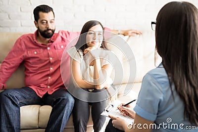 Psychologist taking notes during couple counseling session Stock Photo