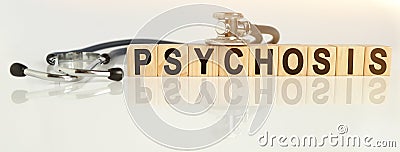 PSYCHOSIS the word on wooden cubes, cubes stand on a reflective white surface, on cubes - a stethoscope Stock Photo