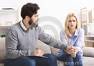 Psychotherapist comforting puzzled female patient at office Stock Photo