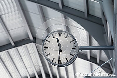 Public clock in railway station at the hanging with roof of subway central train station. It is clock for watch time waiting train Stock Photo