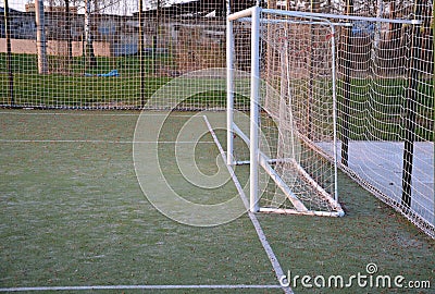 Public multifunctional city playground with green artificial turf. soccer goals. protective white nets and game lines. around are Stock Photo