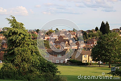 Public park with trees houses and city skyline in background UK Stock Photo