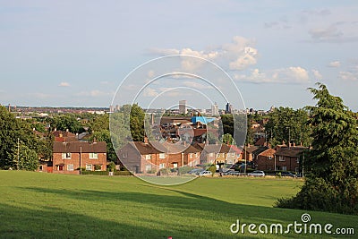 Public park with trees houses and city skyline in background UK Stock Photo