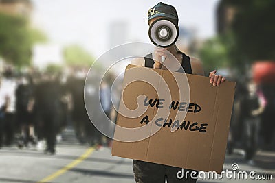 public protest and riots in the city streets. woman with megaphon and cardboard poster in hands on protesters crowd background Stock Photo