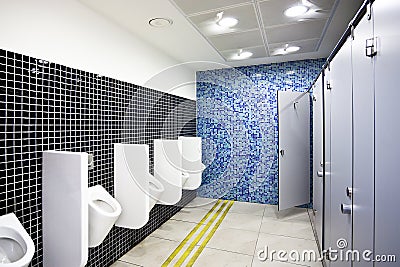 Public toilet with cubicles and urinals Stock Photo