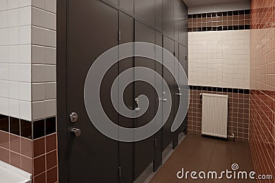 Public toilet interior with stalls and tiled walls Stock Photo