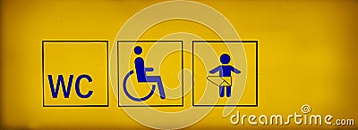 Public toilets signs with a handicapped accessible symbol and baby changing room on yellow neon sign Stock Photo