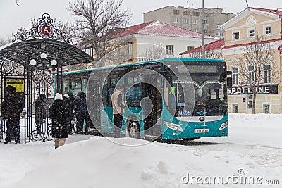 public urban transport in Kazakhstan, city bus at the bus stop, passengers waiting for the bus Editorial Stock Photo