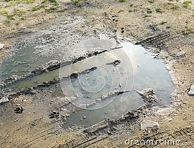 Puddle and mud with tire track texture. Muddy field, dirt road after rain. Impassibility Of Roads. Helplessness concept Stock Photo