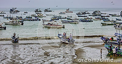 Puerto Lopez, Ecuador - September 12, 2018 - Fishermen finish their day fixing nets, cleaning boats, and talking with Editorial Stock Photo