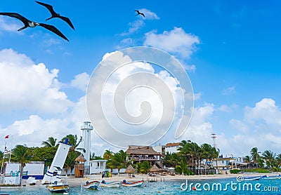 Puerto Morelos seaside view with sea, lighthouse, birds and boats. Caribbean sky with clouds. White sand shore. Background or wall Stock Photo