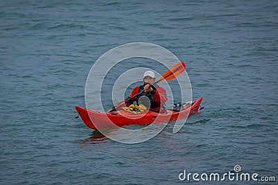 PUERTO VARAS, CHILE, SEPTEMBER, 23, 2018: Unidentified man on orange kayak enjoying the day in the water in Puerto Varas Editorial Stock Photo
