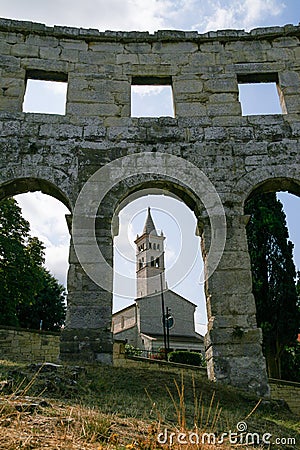 Church through the arches of Pula Arena Editorial Stock Photo