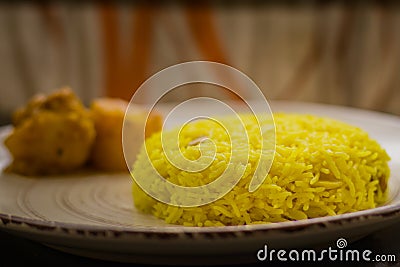 Pulav and potato curry served on a plate. Traditional Bengali basanti polao or sweet polao or fried rice served as offering to the Stock Photo