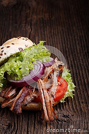 Pulled pork burger with coleslaw tomato, onion and fresh bread. Stock Photo