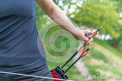 Pulling an arrow out of the holster at archery races Stock Photo