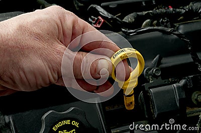 Pulling the dipstick to check oil level Stock Photo