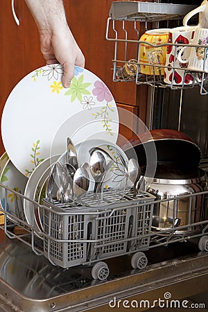 Pulling plate out of dishwasher Stock Photo