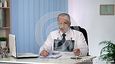 Pulmonologist examining patients x-ray, lung cancer diagnostics, clinic services Stock Photo