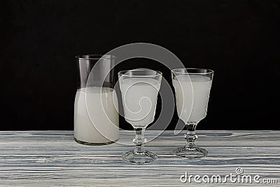 Pulque or pulke in drinking glasses on dark background. Traditional mexican beverage made from fermented sap of maguey agave Stock Photo