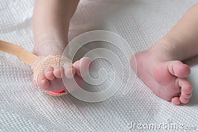 Pulse oximeter sensor on the feet of newborn baby in a hospital bed close-up Stock Photo