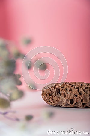 Pumice stone close up and copy space. Pumice stone 3d on a pink background and dry plants. Beauty concept. Background for cosmetic Stock Photo