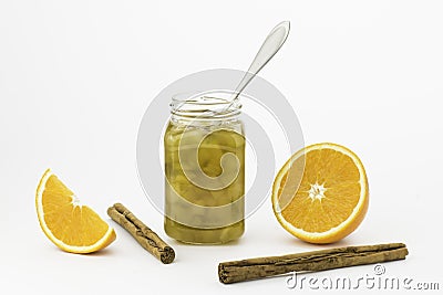Pumkin jam jar with a silver spoon, cinnamons sticks and orange slices Stock Photo
