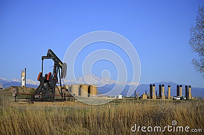 Pump Jack Oil Well with Longs Peak and tank farm Stock Photo