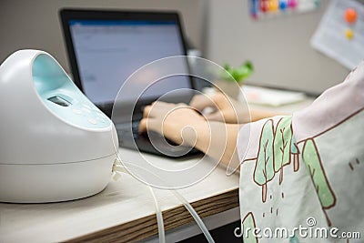 pumping breastmilk and working in office Stock Photo