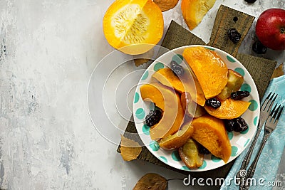 Pumpkin baked with apples, prunes and spices in a bowl on a stone background. Stock Photo
