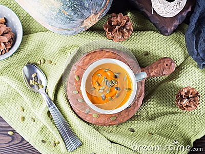 Pumpkin cream soup in green mugs. Rustic style Stock Photo