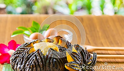 Pumpkin custard in pumpkin fruit cooking with hot steaming, Thai dessert menu served on the table in the garden at home. Stock Photo