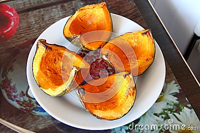 Pumpkin cut into quarters on a plate Stock Photo