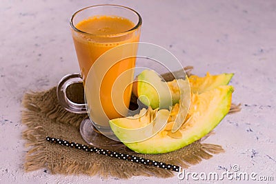 Pumpkin juice in a high glass on a white background. Concept of healthy autumn drinks. Stock Photo