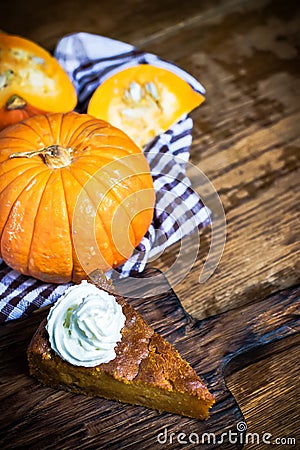 Pumpkin pie with whipped cream on rustic background. Stock Photo