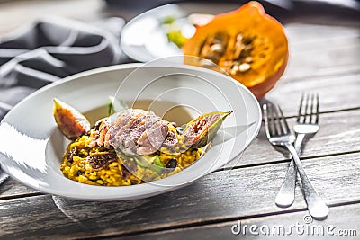 Pumpkin risotto roasted duck breast figs zucchini and min leaves. italian or mediterranean cuisine Stock Photo