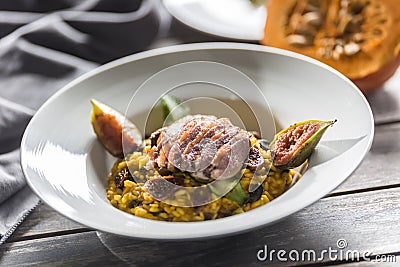 Pumpkin risotto roasted duck breast figs zucchini and min leaves. italian or mediterranean cuisine Stock Photo