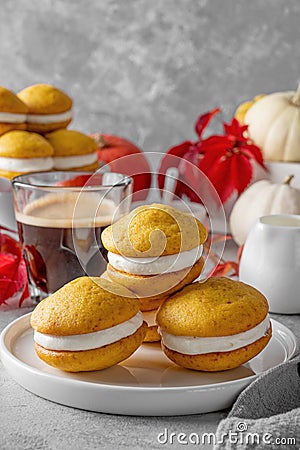 Pumpkin sandwich cookies with cream cheese on a gray concrete bsckground. Spicy autumn dessert. Copy space Stock Photo