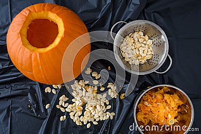 Pumpkin seed harvesting, seeds in a colander and pumpkin guts in a bowl Stock Photo