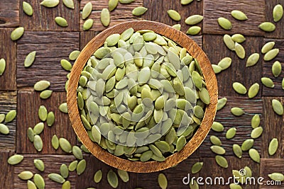 Pumpkin seeds peeled in wooden bowl, top view Stock Photo